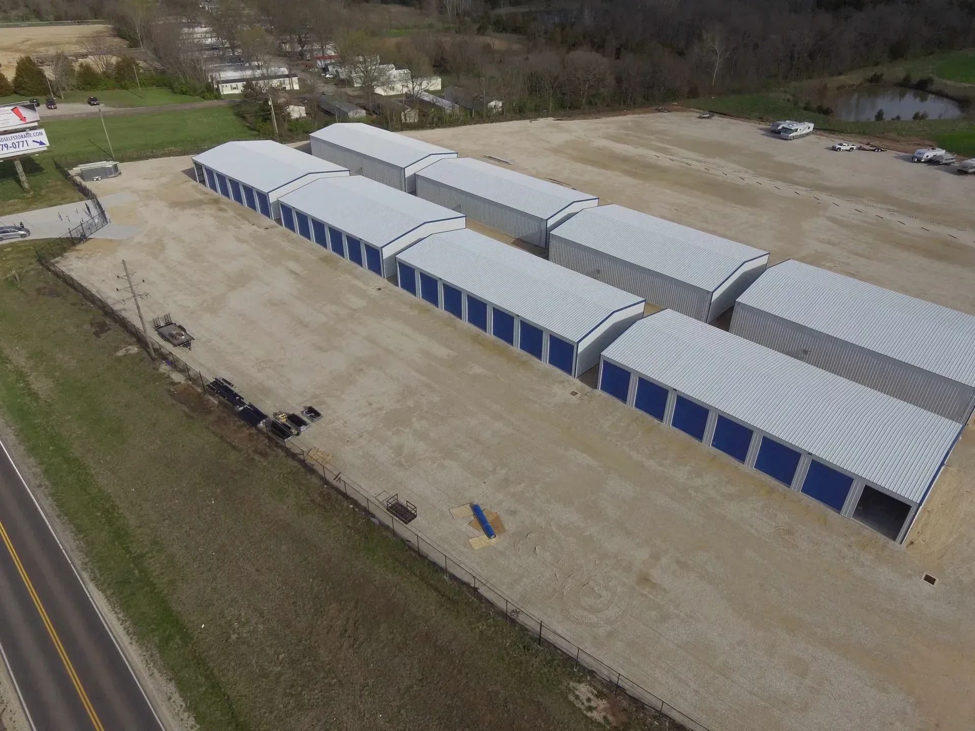 An aerial view of a row of storage units next to a road.