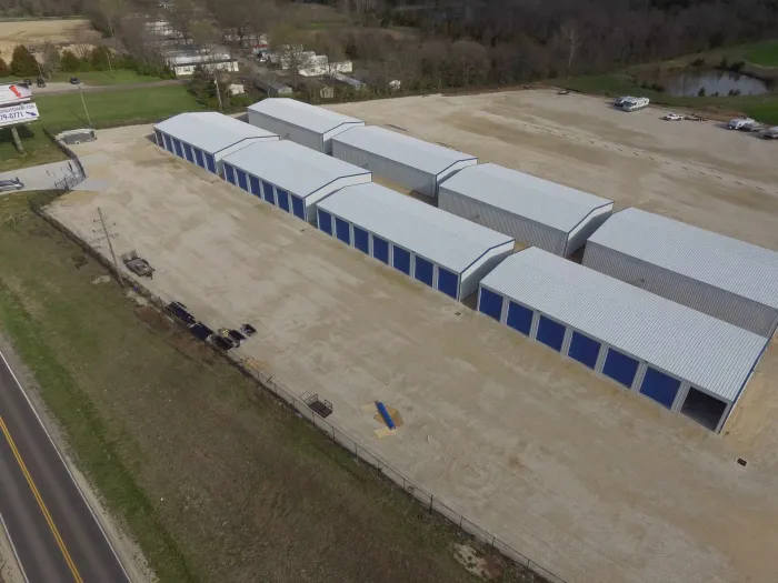 An aerial view of a row of storage units next to a road.