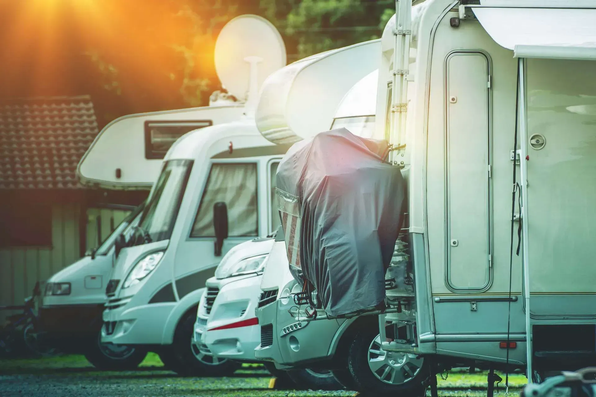 A row of rvs parked next to each other in a parking lot.