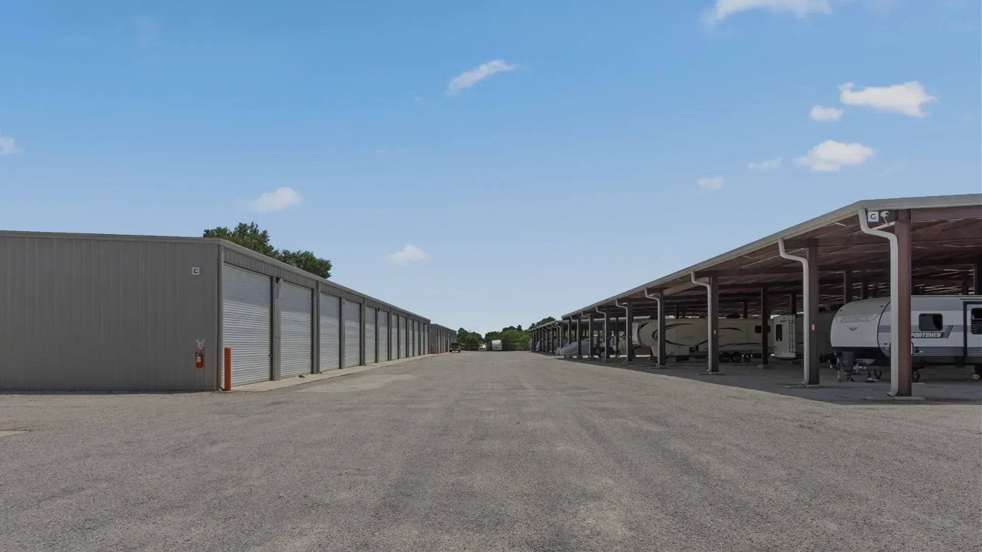 A row of covered parking spaces with rvs parked underneath them.