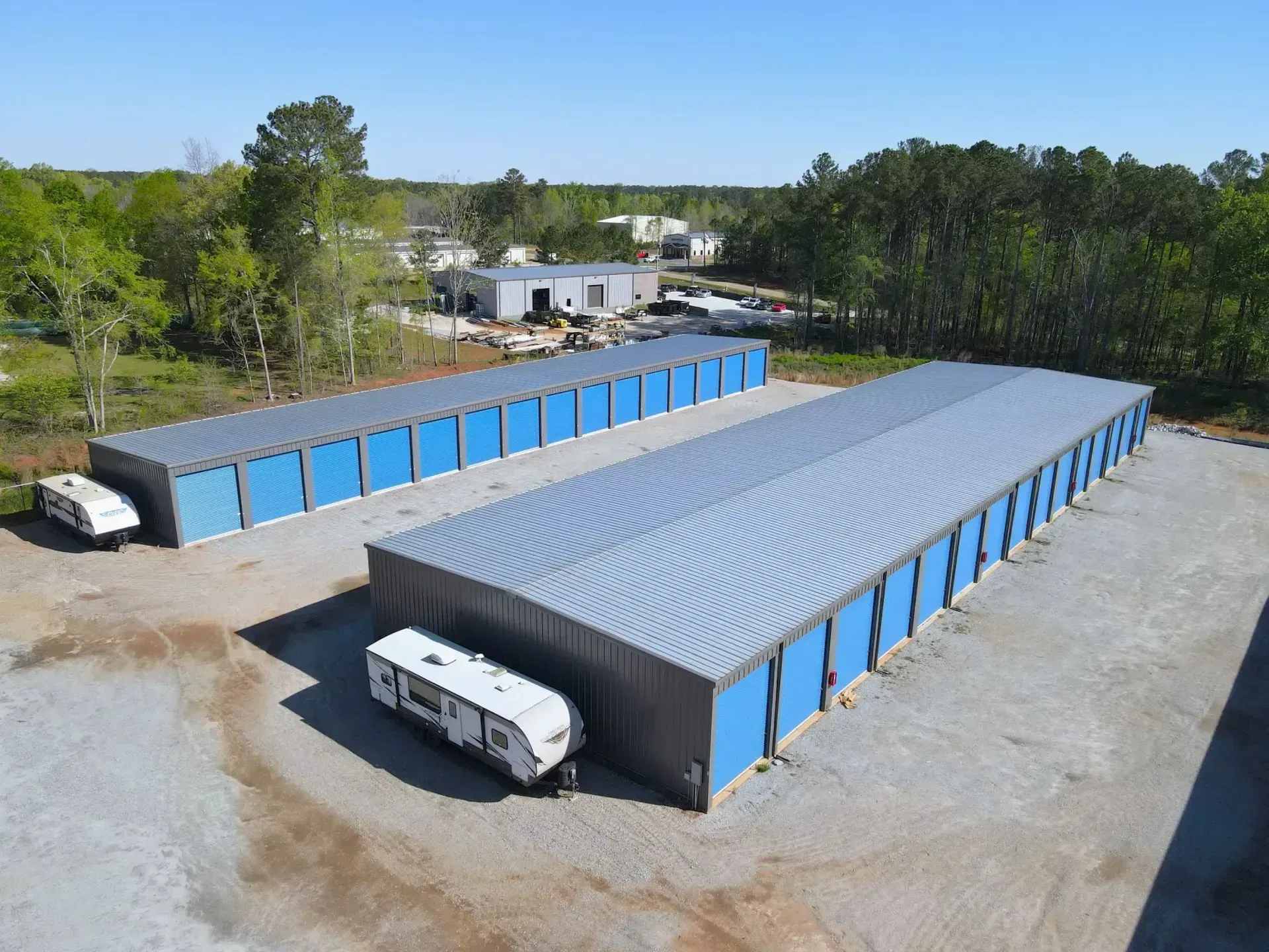 An aerial view of a storage facility with trailers parked in front of it.