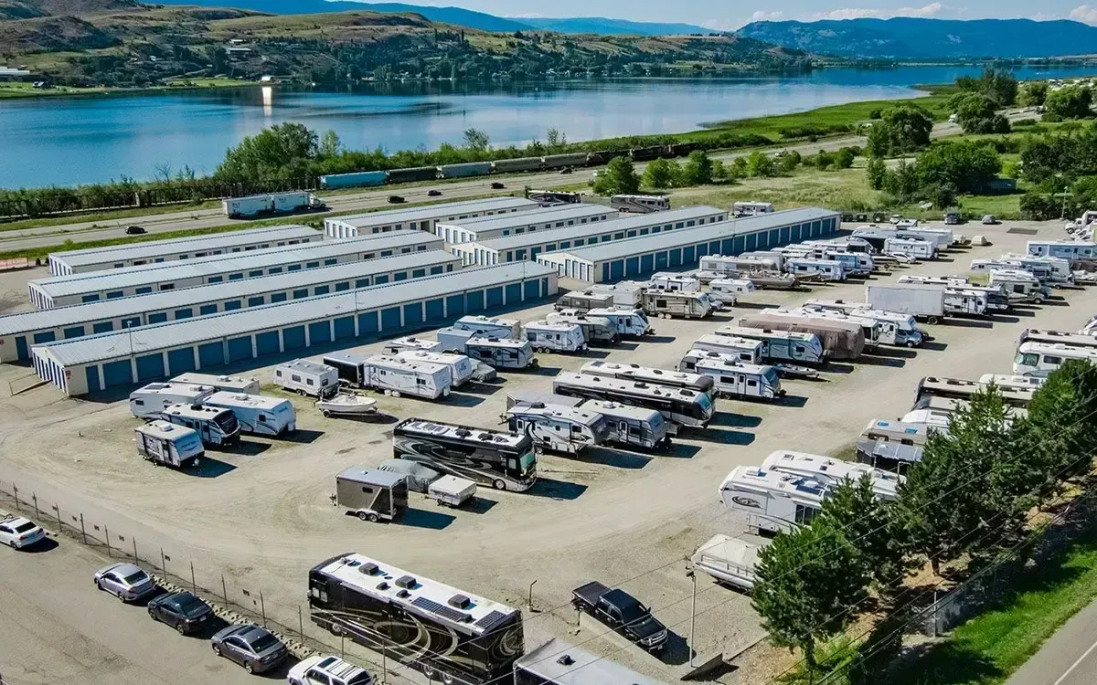 An aerial view of a rv park with a lake in the background.