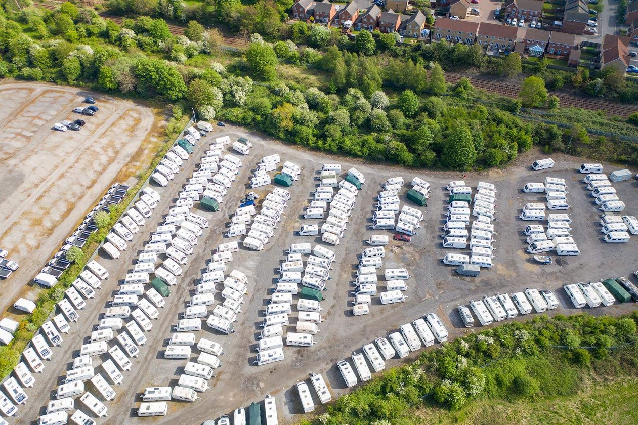An aerial view of a parking lot filled with lots of cars.