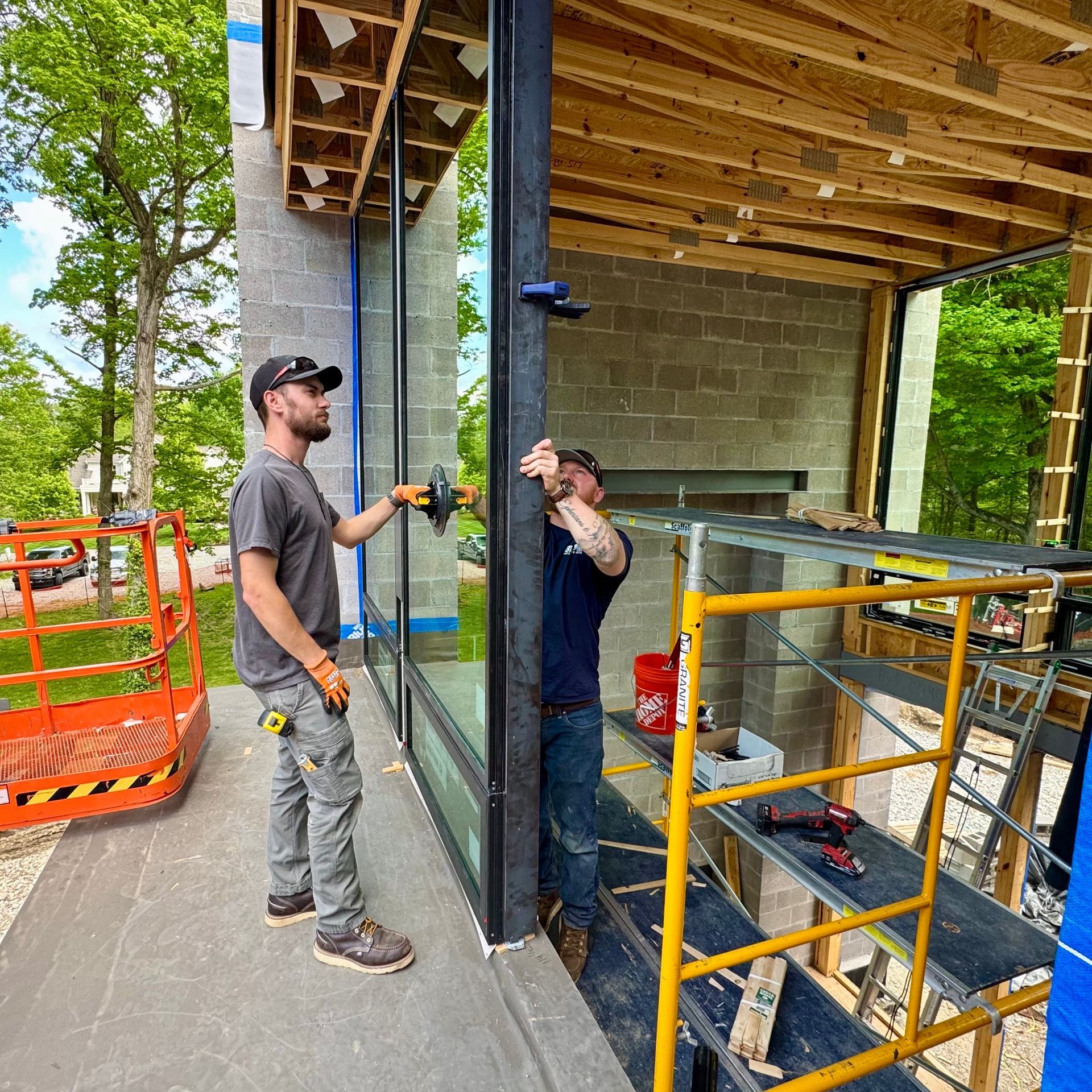 Two construction workers installing a window in a modern building under construction.