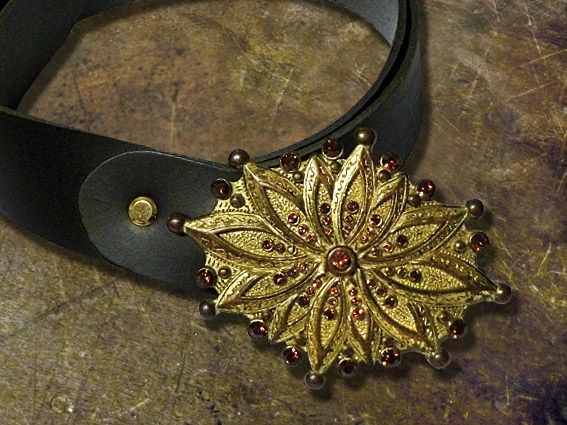 Una cintura di pelle nera con una fibbia dorata