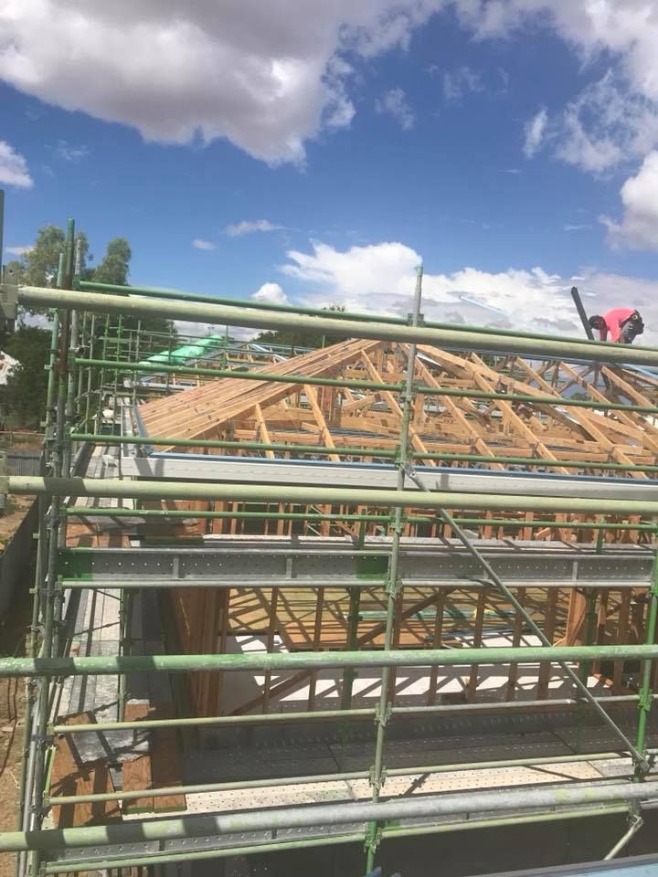 Construction of a Roof With Wooden Trusses, Scaffolding, and a Worker — MJD Roofing Sunshine Coast in Cooroy, QLD