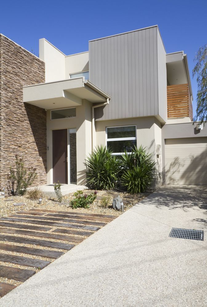 Modern Home Exterior With Stone and Gray Siding; Gravel Path and Wood Walkway — MJD Roofing Sunshine Coast in Cooroy, QLD