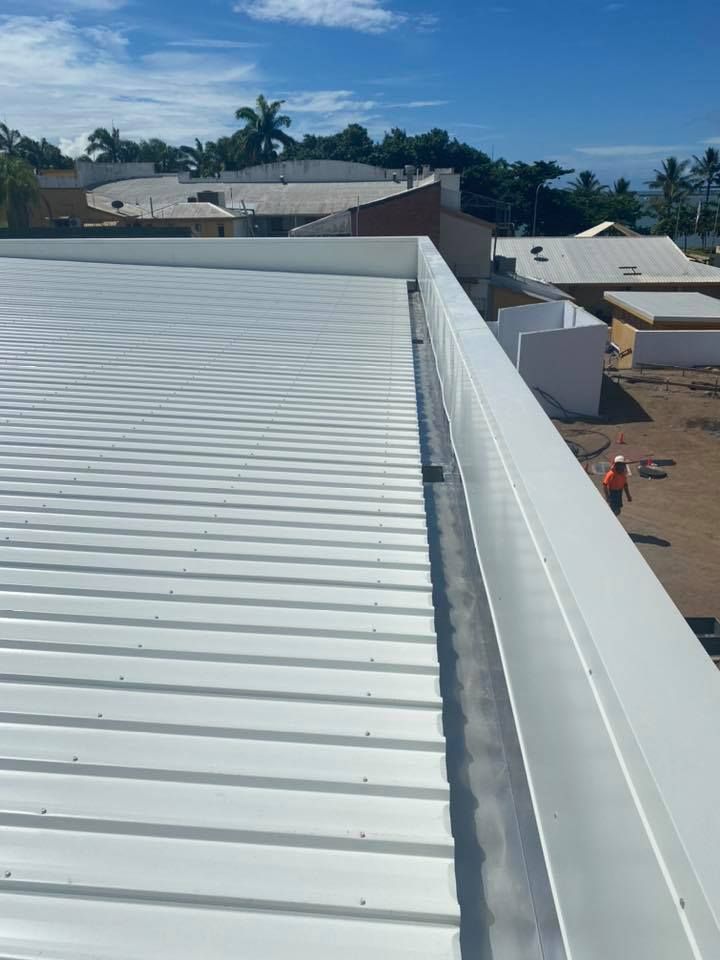 White Metal Roof With Gutter, Buildings in the Background — MJD Roofing Sunshine Coast in Cooroy, QLD