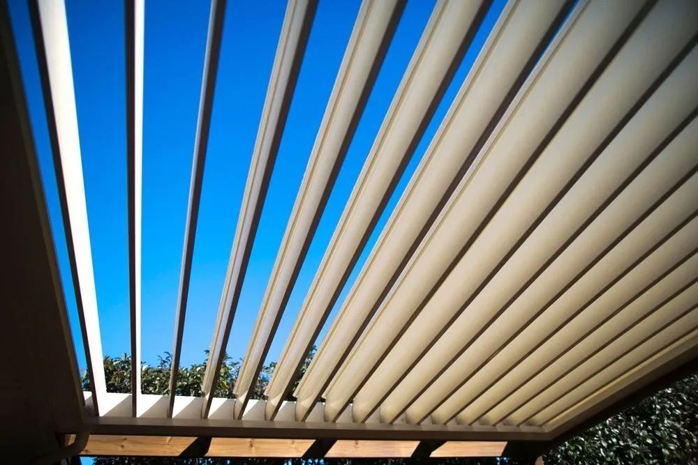 Beige, slatted pergola roof against a bright blue sky — MJD Roofing Sunshine Coast in Cooroy, QLD