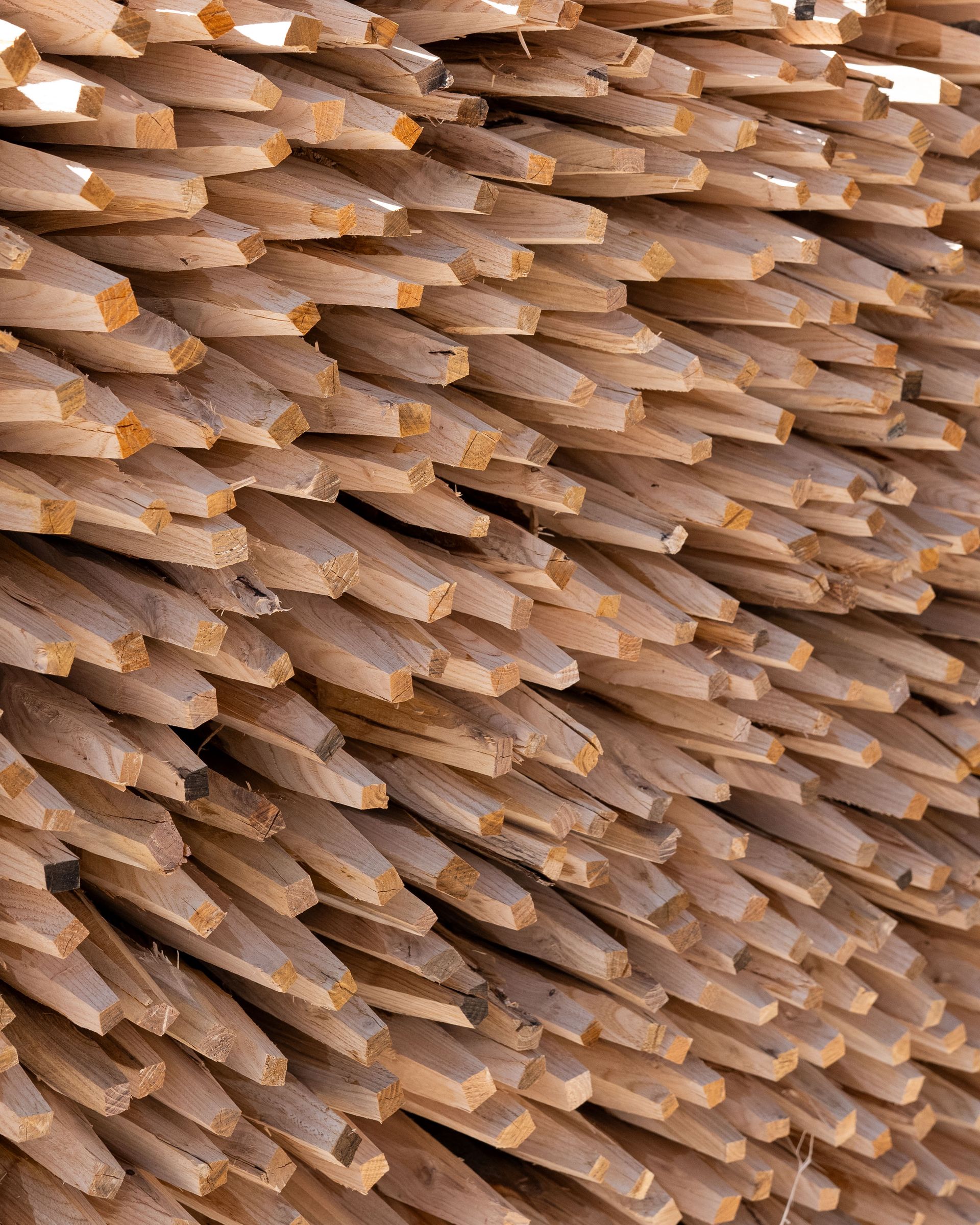 Pila di pali di legno, impilati in diagonale, pronti per l'uso.