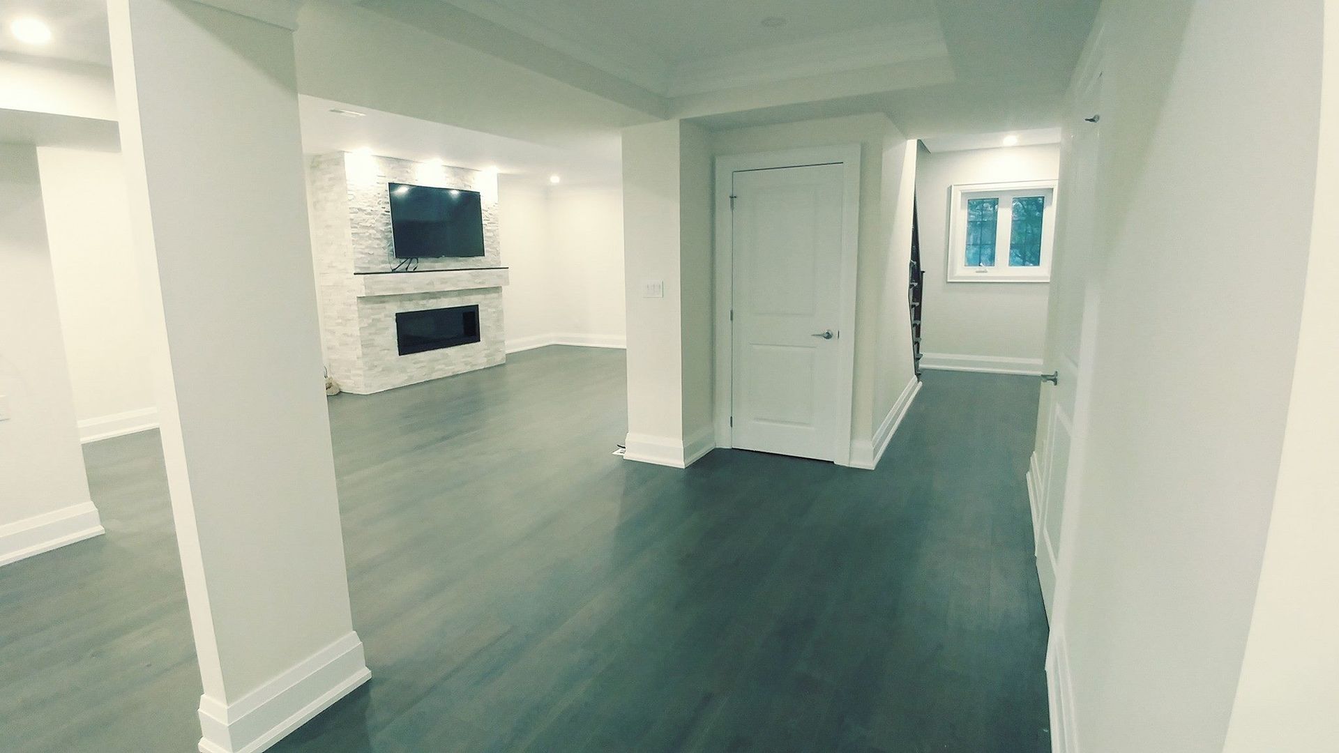 A hallway in a house with a television on the wall