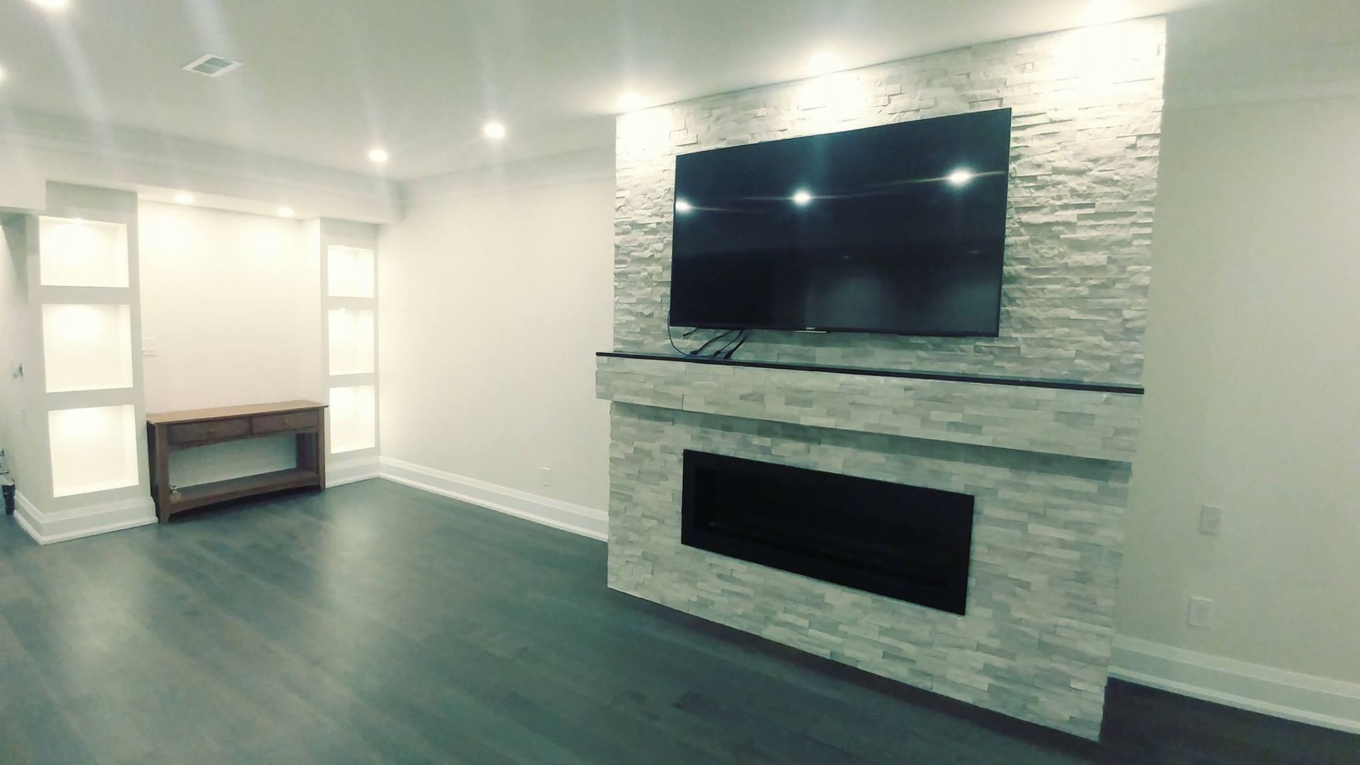 A living room with a fireplace and a flat screen tv on the wall