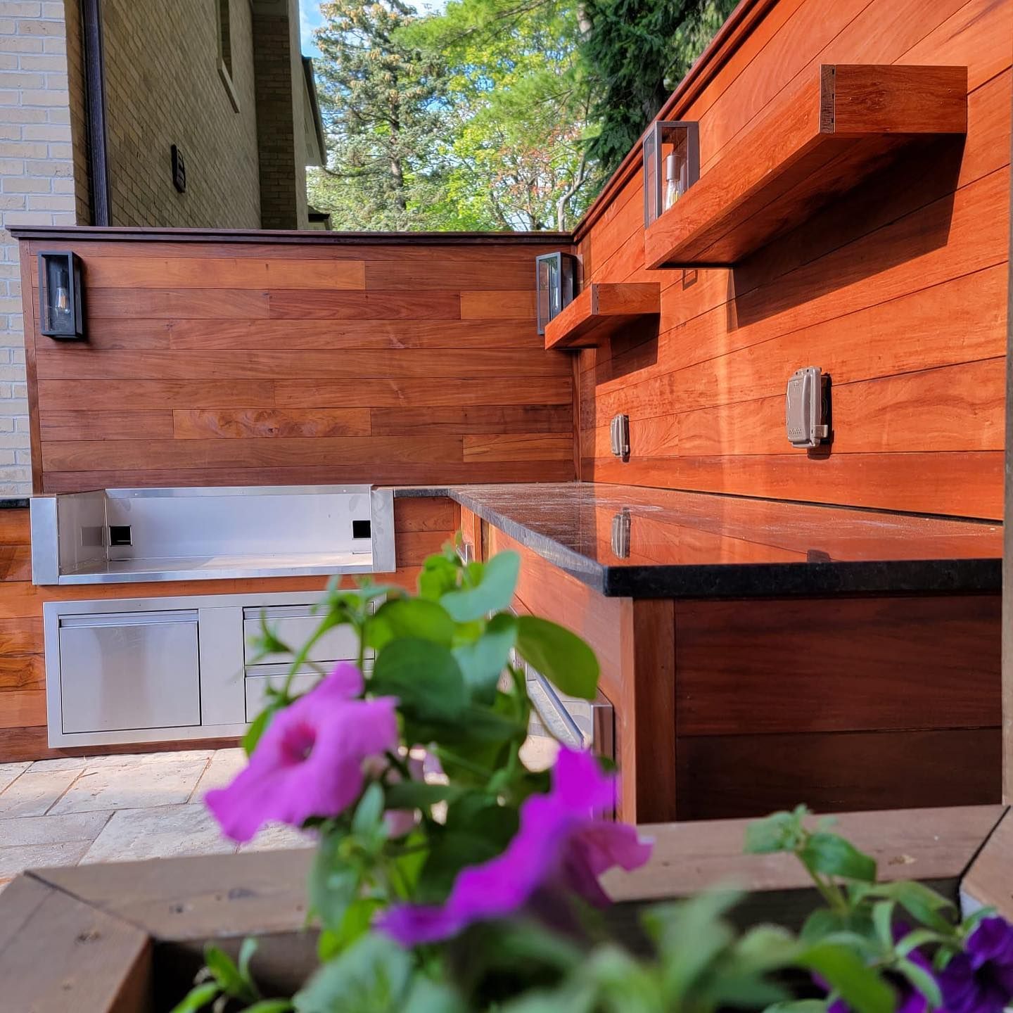 Purple flowers are in front of a wooden kitchen