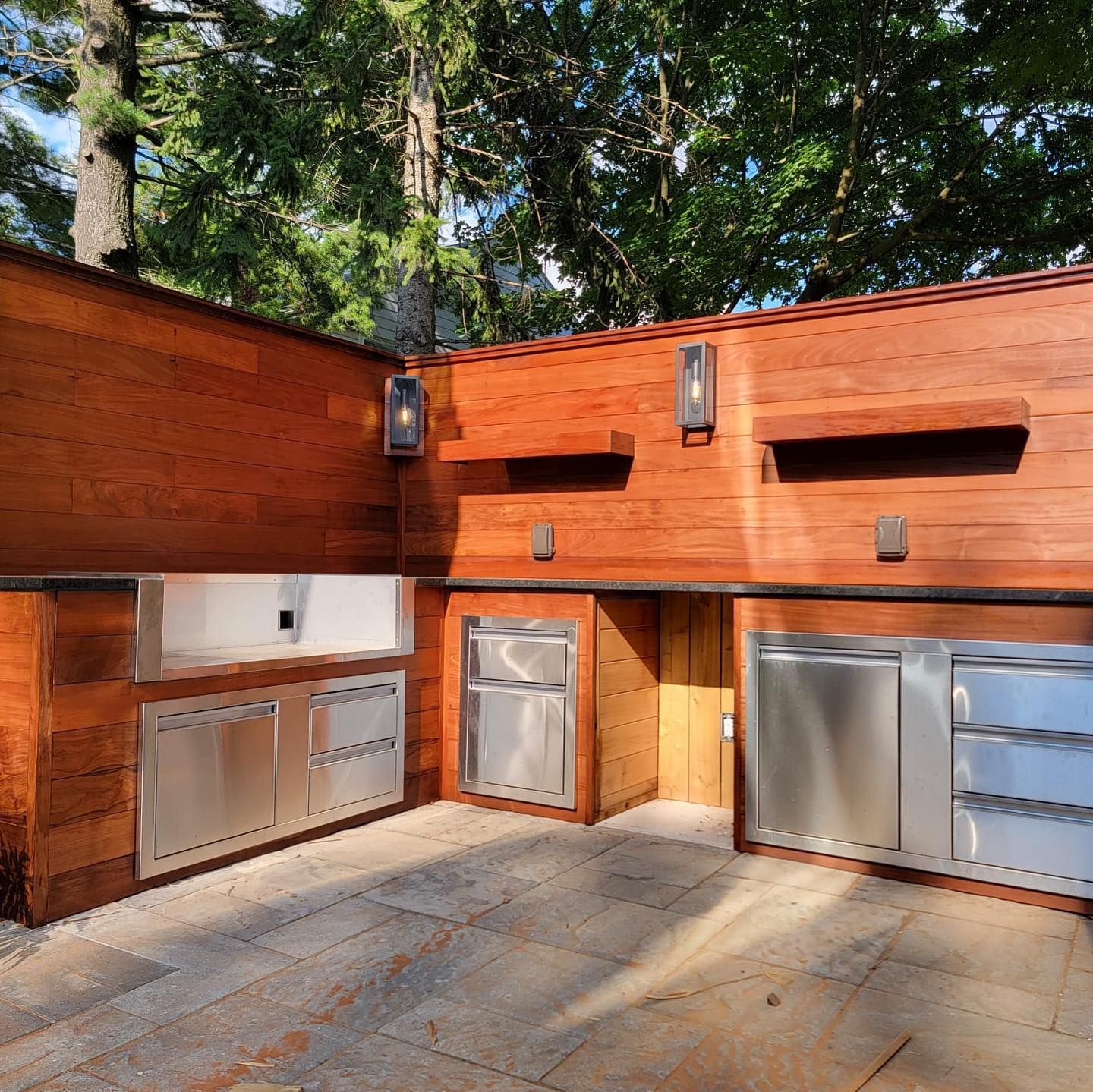 A kitchen with stainless steel appliances and a wooden wall