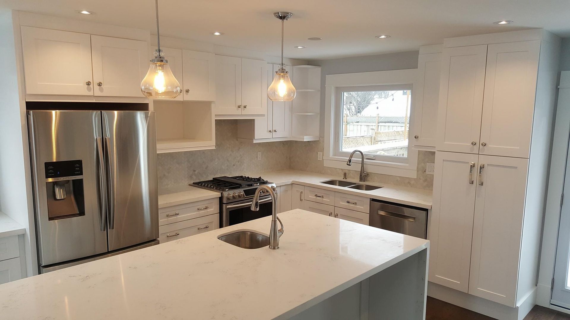 A kitchen with white cabinets and stainless steel appliances