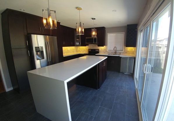 A kitchen with a large island and sliding glass doors