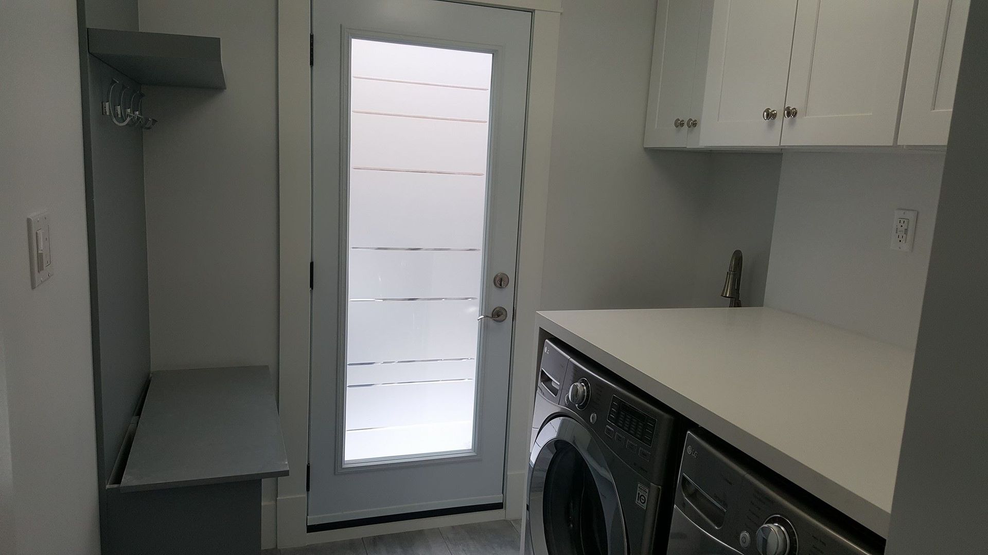 A laundry room with a washer and dryer and a door.