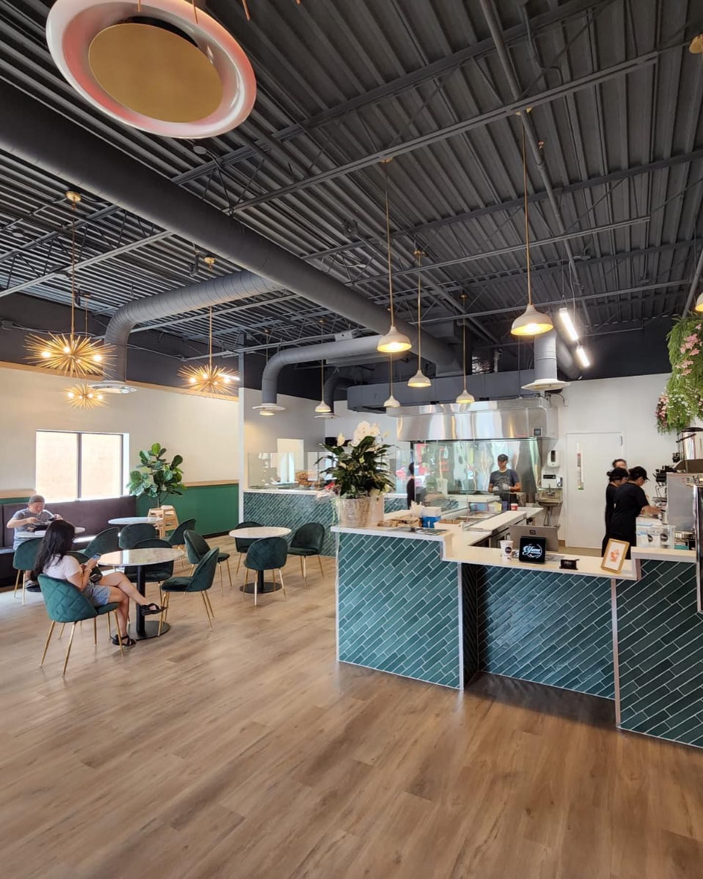 A restaurant with people sitting at tables and a counter