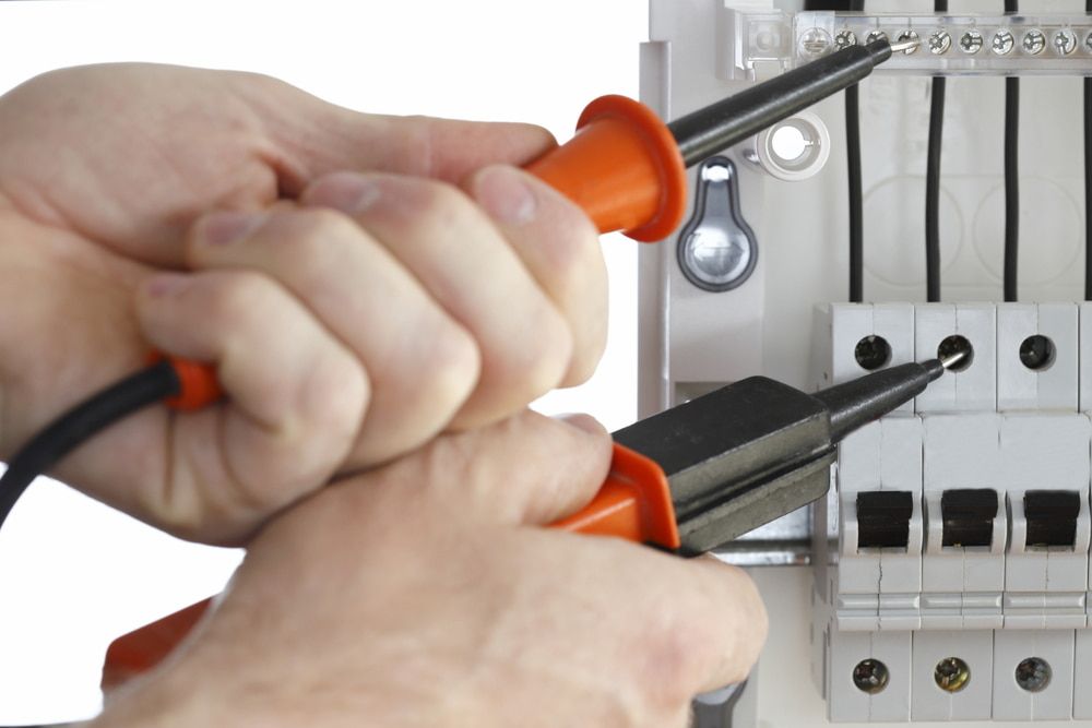 A Person Is Working On A Circuit Board With A Pair Of Pliers — Lex Electrix In West End, QLD