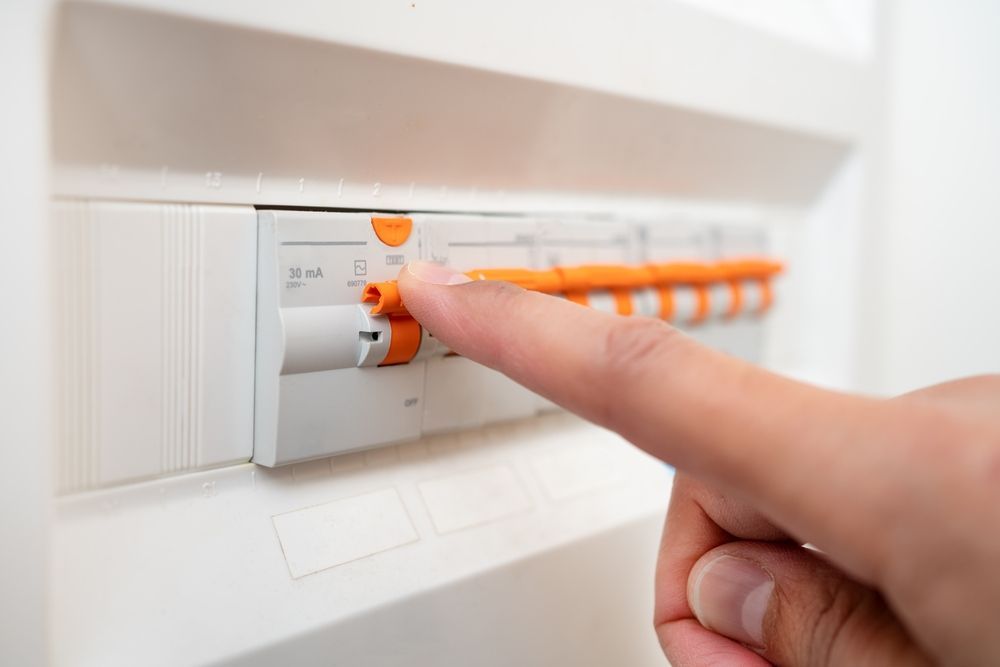 A Person Is Pressing A Button On An Electrical Box With Their Finger — Lex Electrix In West End, QLD