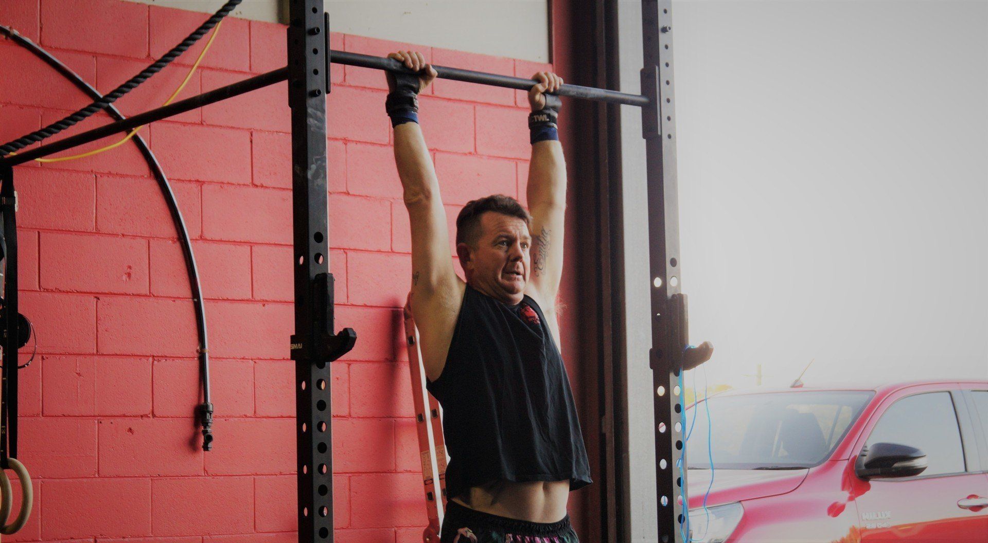 Image of woman lifing weights overhead at CrossFit classes