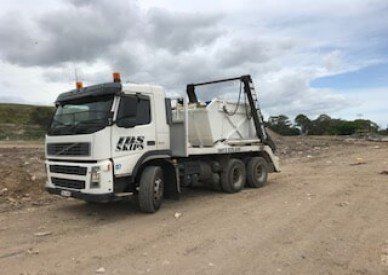 Truck Delivering a Empty Waste Skip — Skip bin hire in Mapleton, QLD