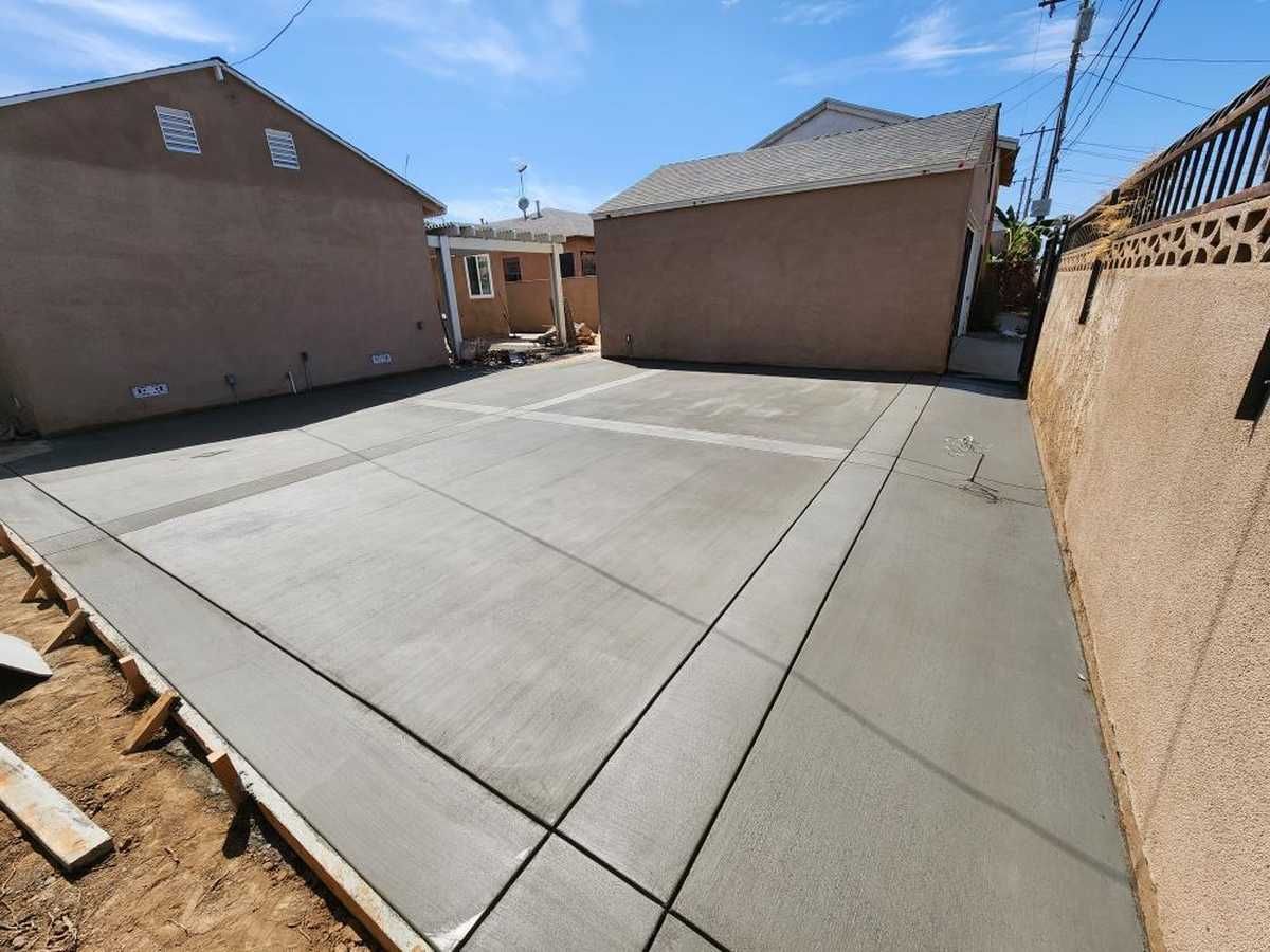 A concrete driveway is being built in front of a house