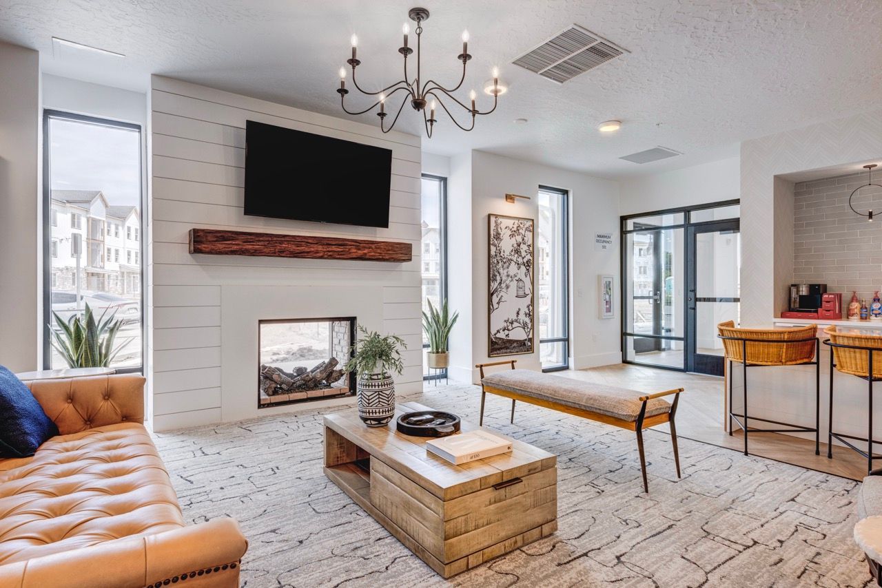 Aria apartment community lounge with a fireplace, TV, and seating.