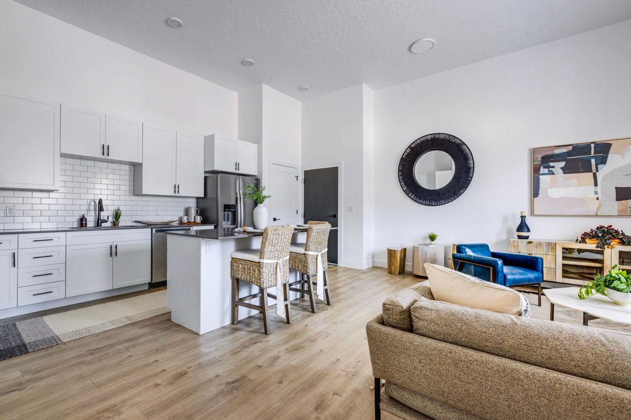 Aria kitchen and living area with white cabinets, an island, and seating.