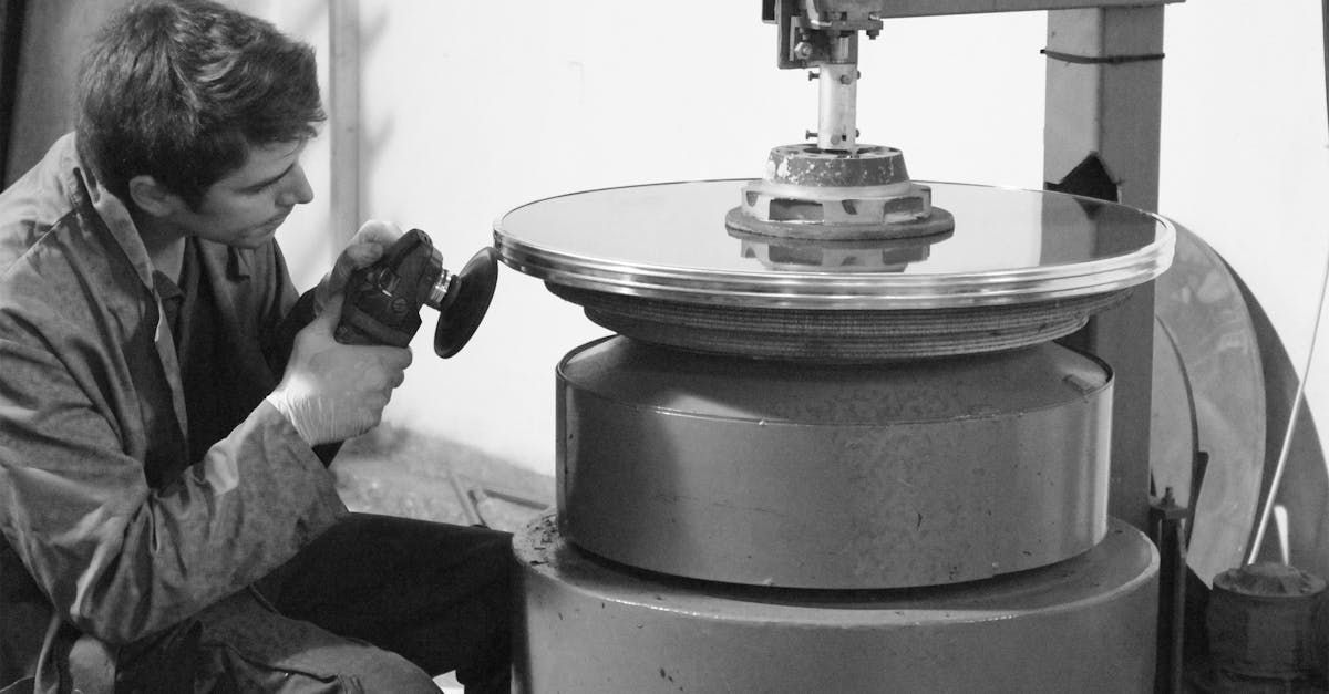 A man is working on a machine in a black and white photo.