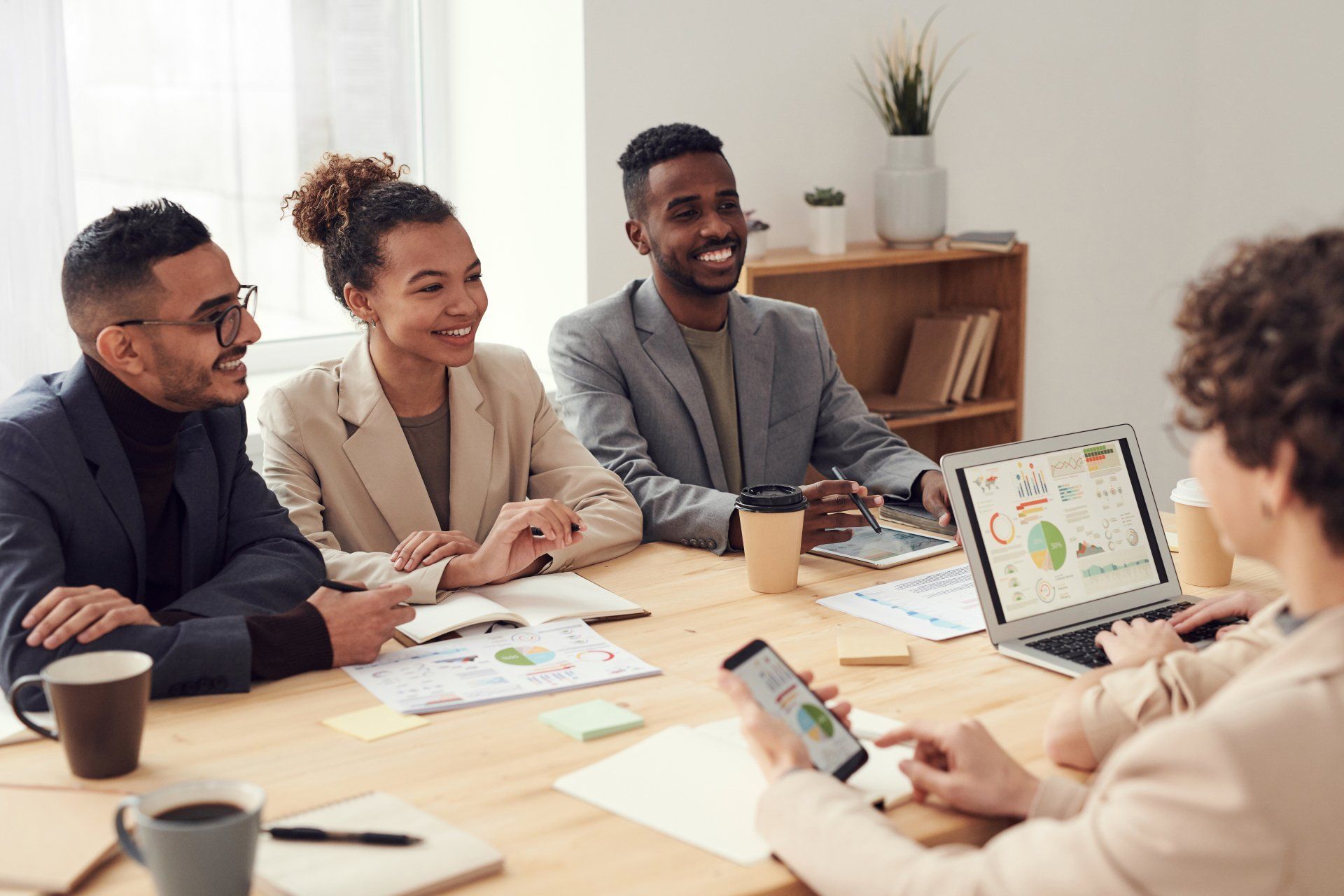 A group of people are sitting around a table having a meeting.