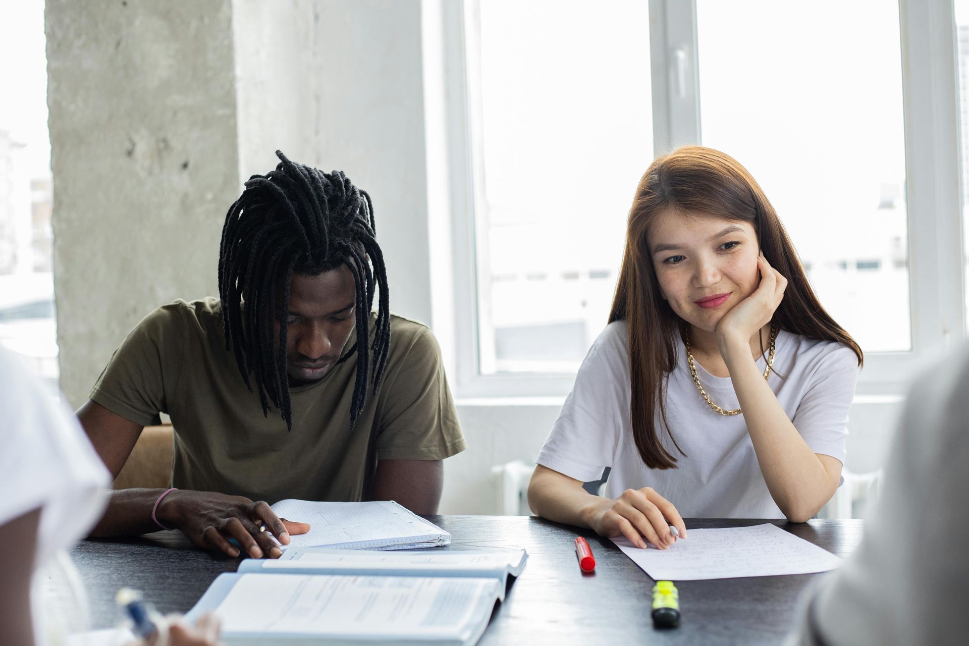 A man and a woman are sitting at a table in a classroom.