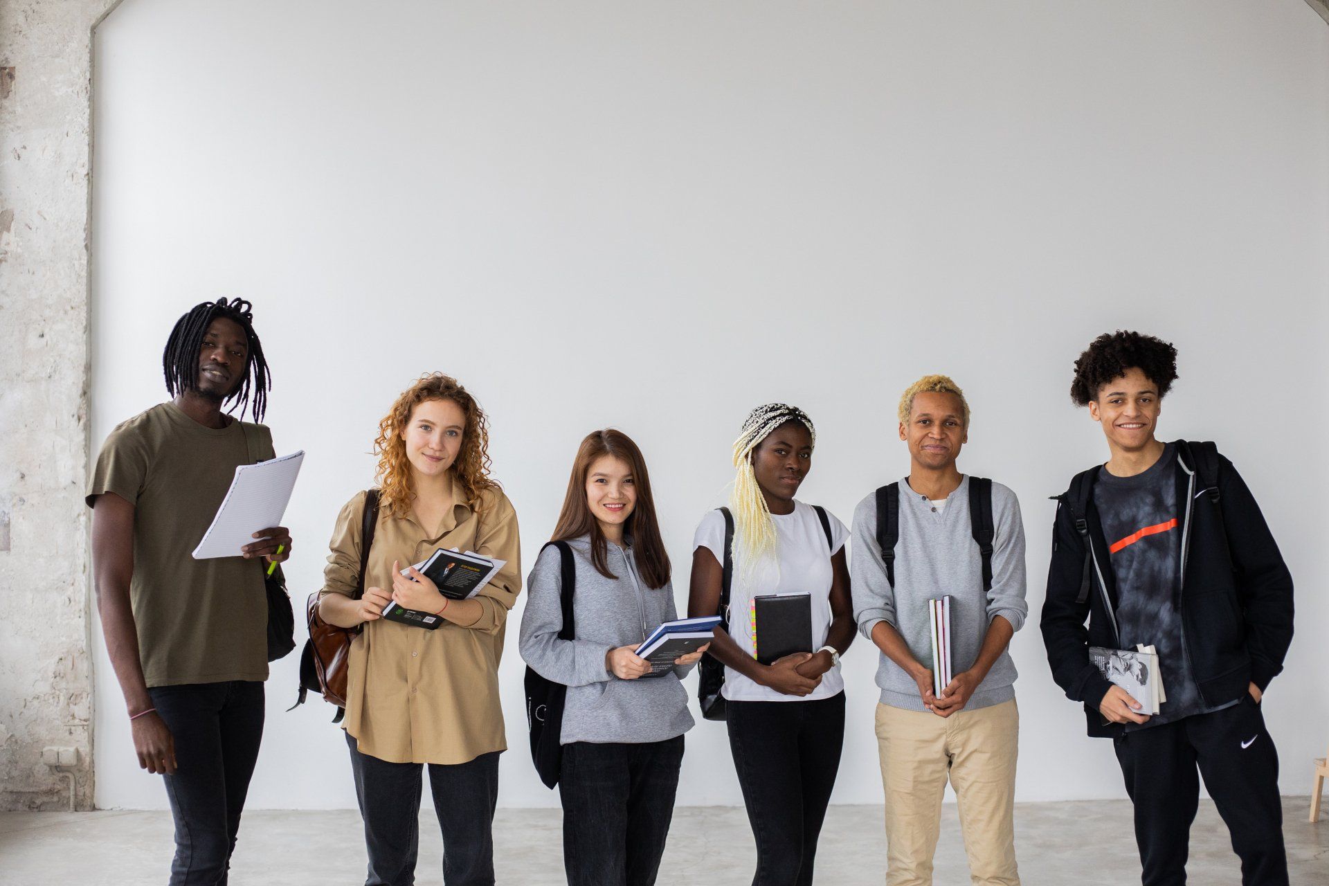 a group of young people are standing next to each other in a room .