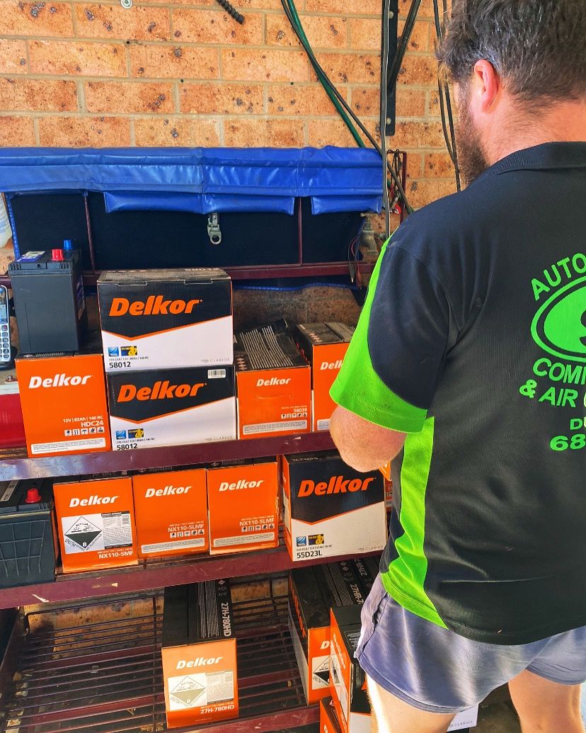 A man standing in front of a shelf of delkor batteries