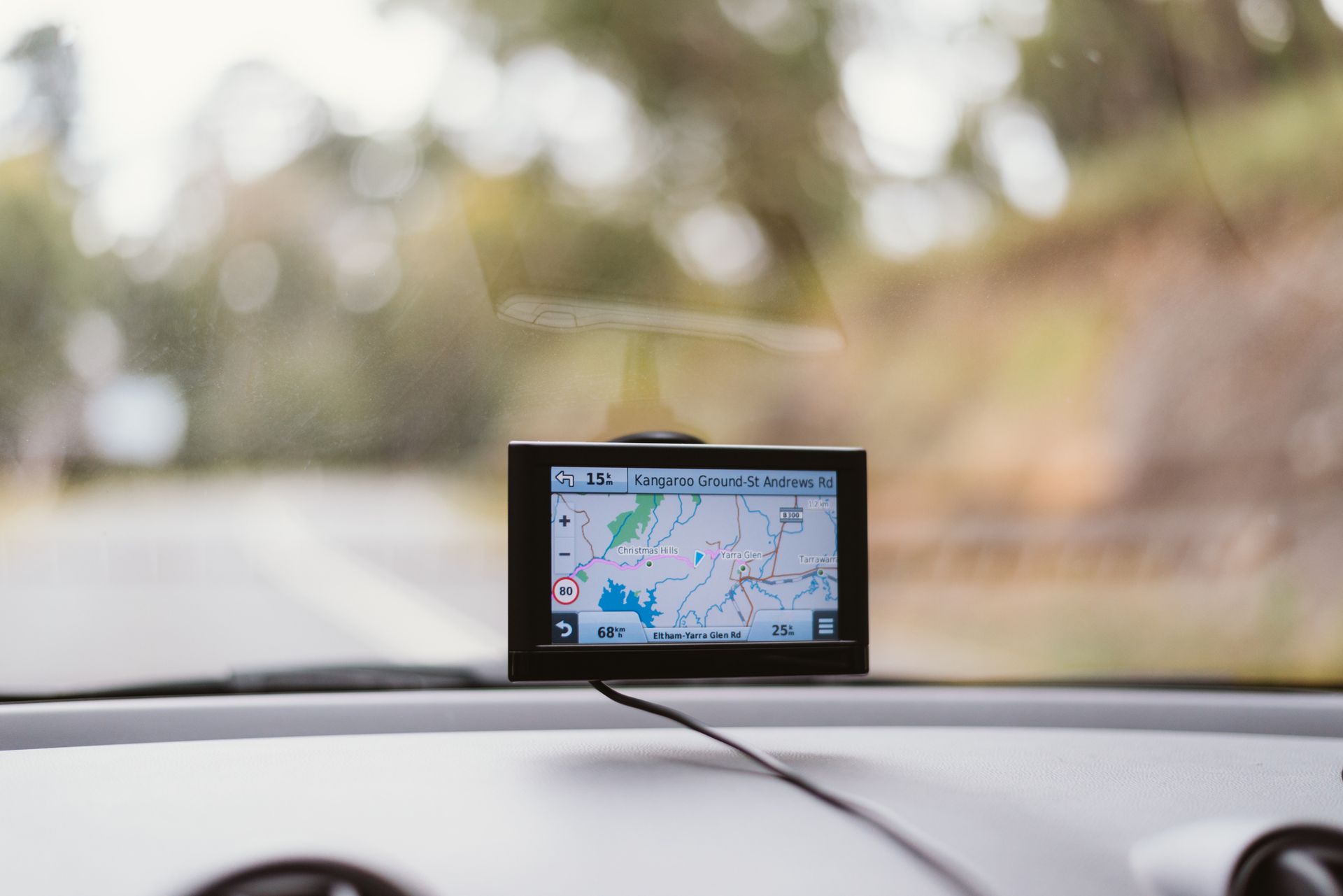 A gps device is sitting on the dashboard of a car.