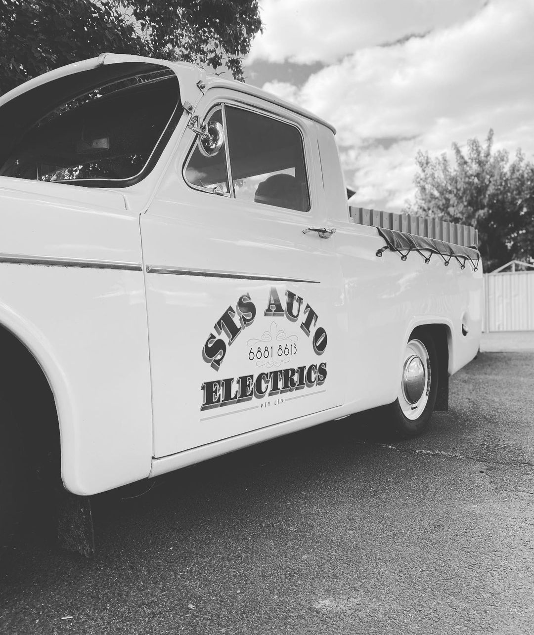 A black and white photo of a sts auto electrics truck