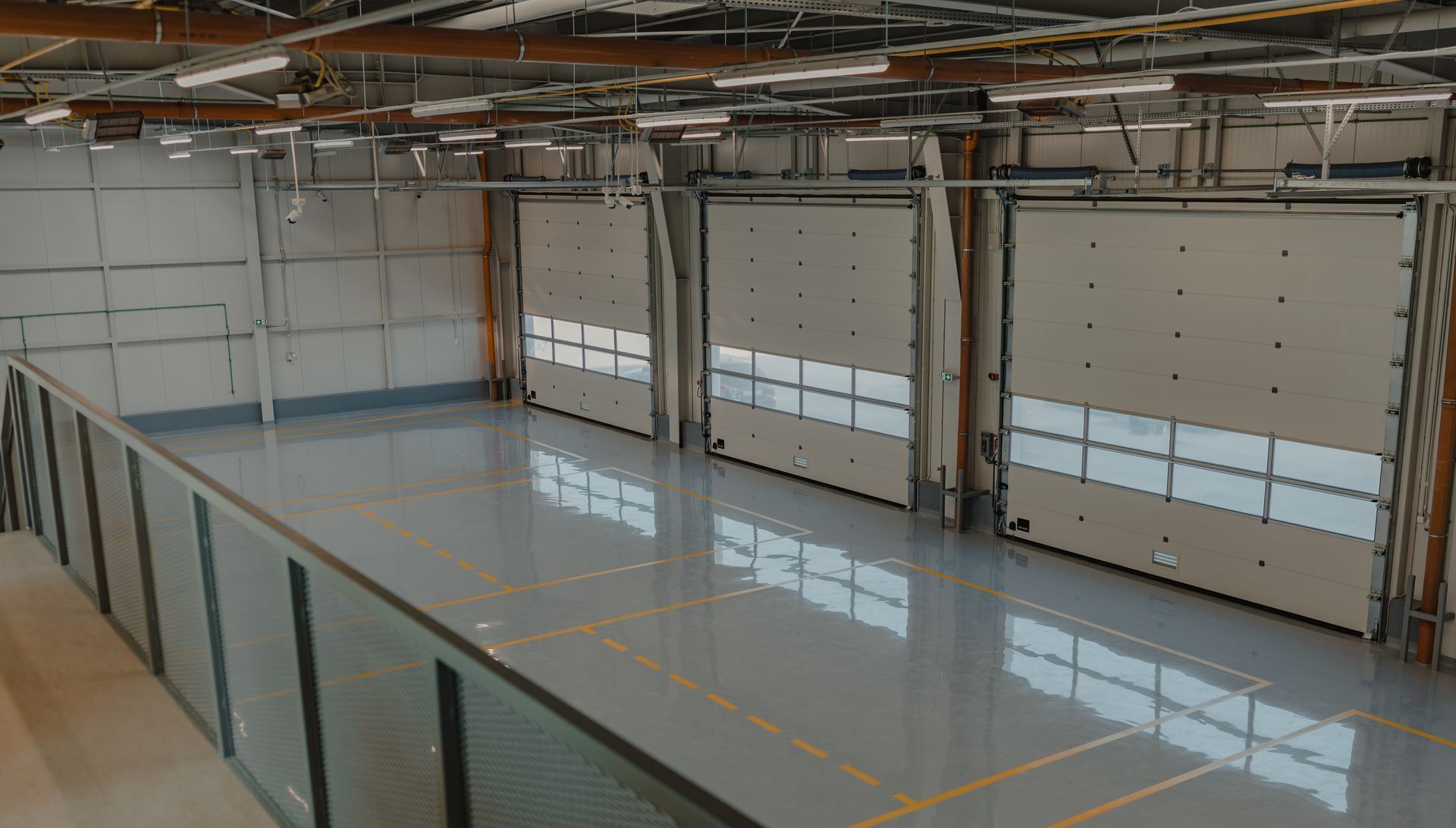 A large warehouse with a lot of doors and a balcony.