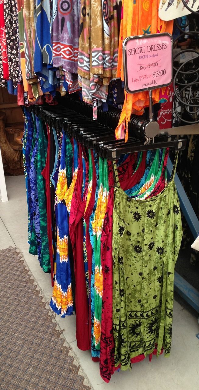 A bunch of clothes are hanging on a rack in a store.