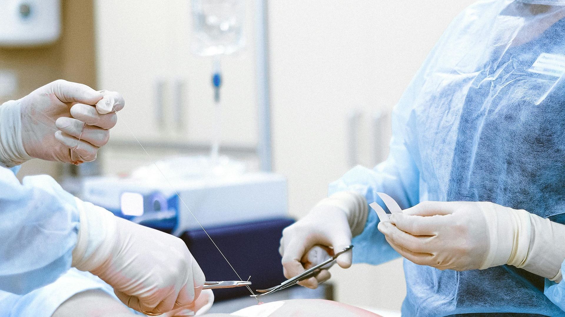 A group of surgeons are performing surgery on a patient in an operating room.