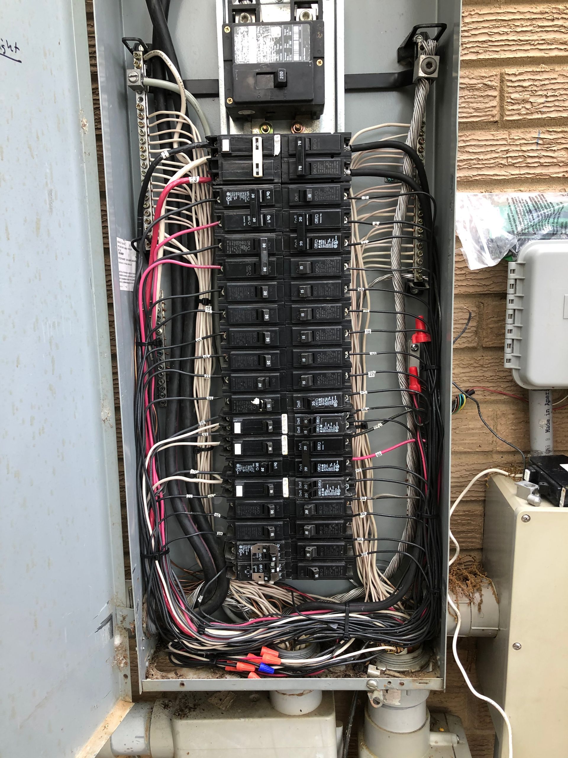 a very old electrical box with a lot of wires coming out of it .