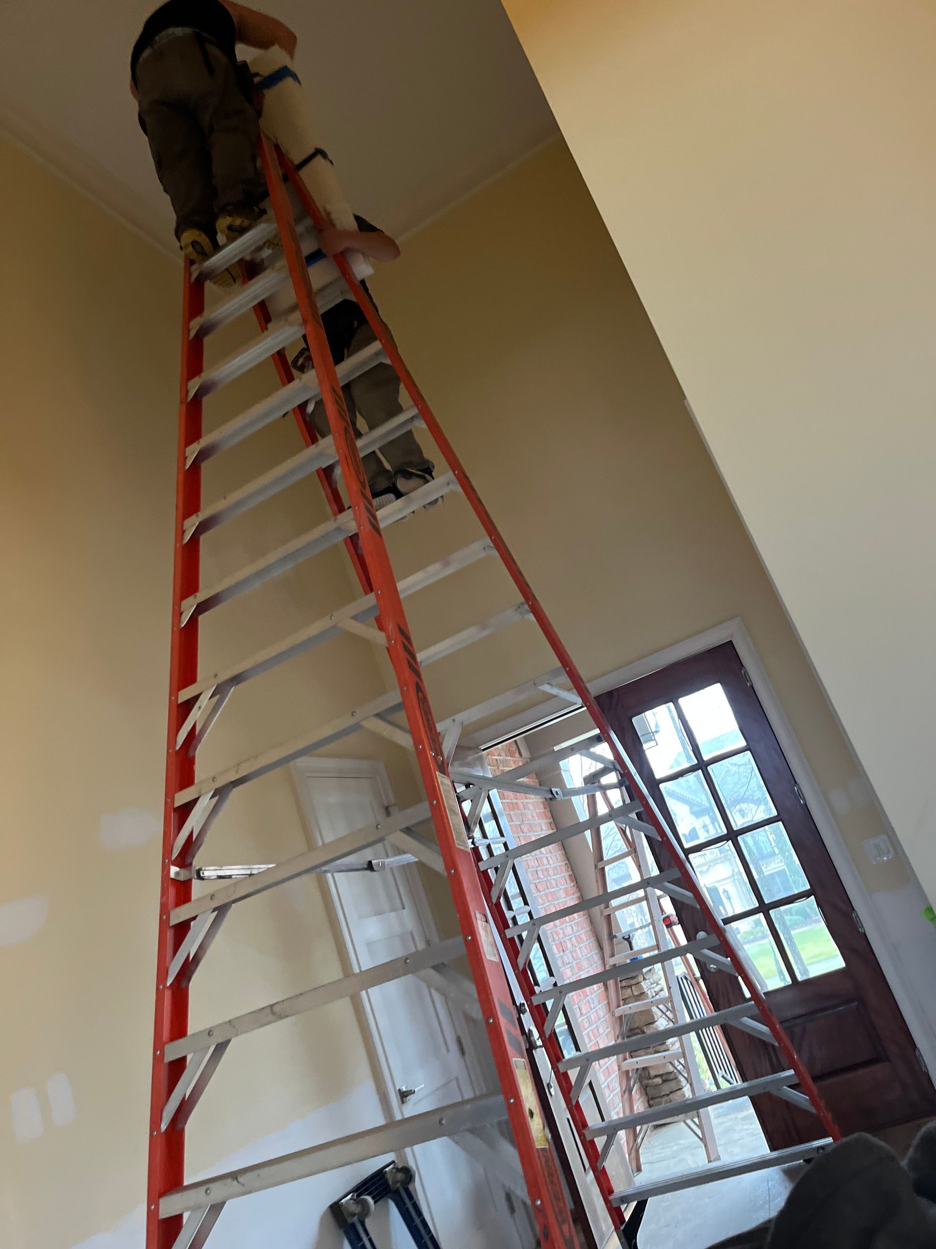 a man is standing on a ladder in a room