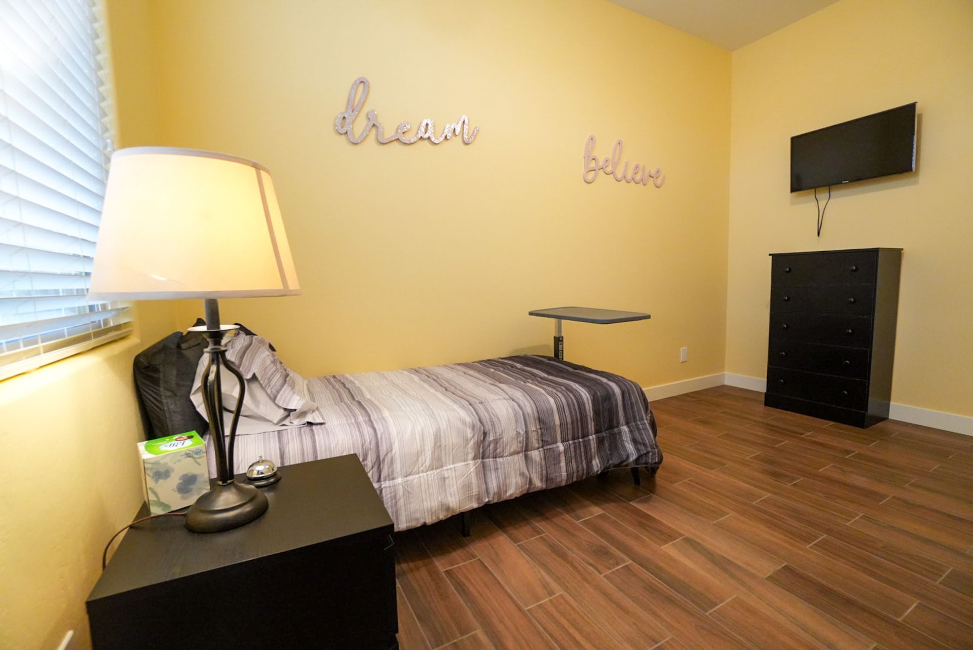 Bedroom with bed, nightstand, TV, dresser, 