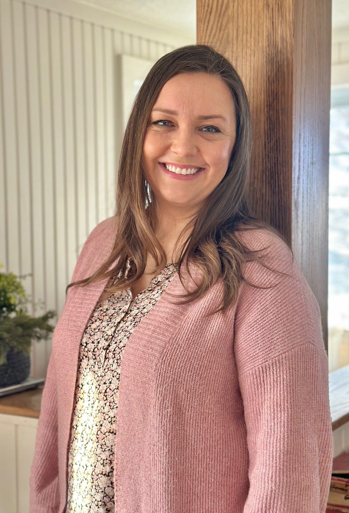 A woman is sitting at a desk with a pen in her hand.