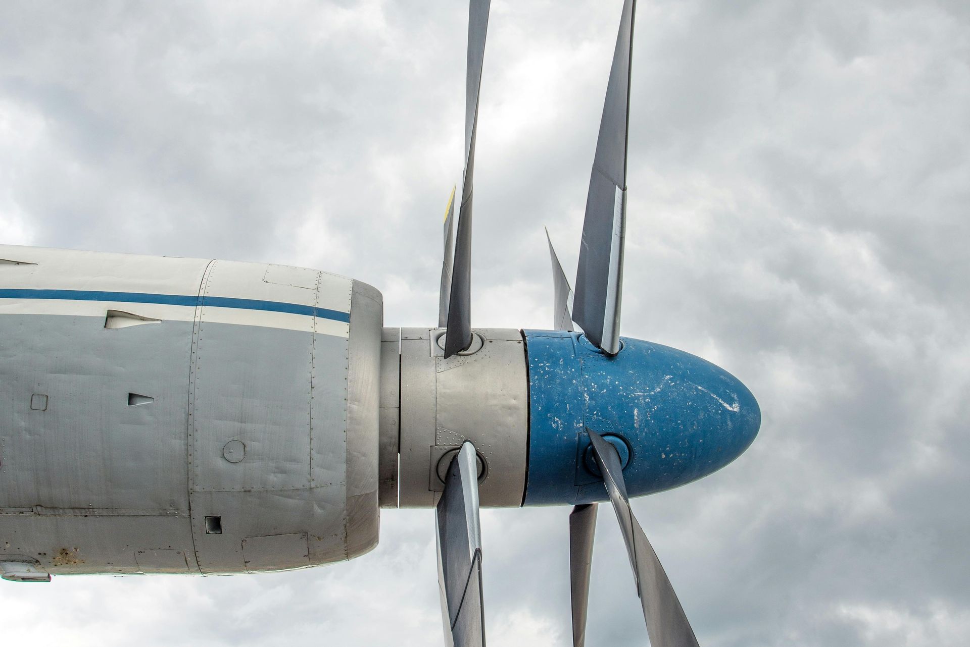 A close up of a plane 's propeller against a cloudy sky
