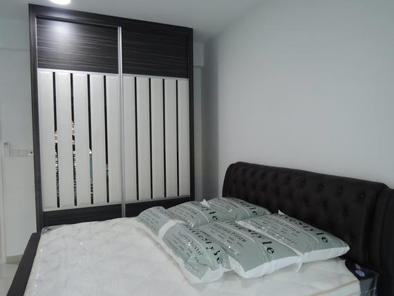 Bedroom with a dark bed and a closet with white and black sliding doors.