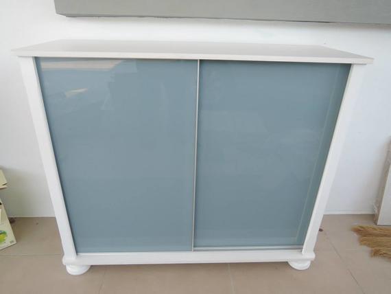White cabinet with two sliding blue-gray glass doors.