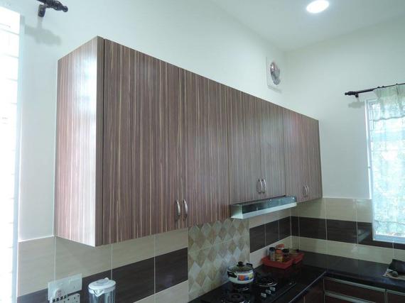 Kitchen cabinets above a tiled backsplash, brown wood grain texture, mounted on a white wall.