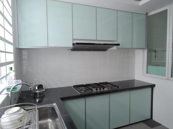 Kitchen with light blue cabinets, black countertop, stove, and sink.