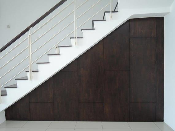 Staircase with white steps, metal railing, and dark wood paneling underneath.