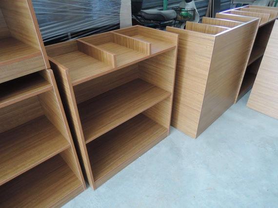 Wooden shelves in a row, with a light wood grain finish. Some have dividers.
